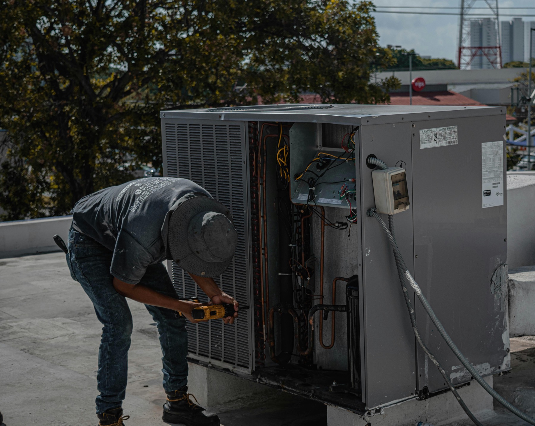 Technician servicing a rooftop commercial HVAC unit
